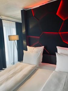 a bedroom with a black and red wall at DORMERO Hotel Aschaffenburg in Aschaffenburg