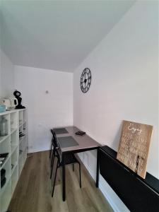 une chambre avec une table et une horloge sur le mur dans l'établissement Studio confort calme centre de Reims Boulevard de la Paix, à Reims