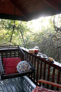 a porch with a hammock and a bench on a deck at Thulamela Couples Retreat in Hazyview