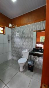 a bathroom with a toilet and a sink and a mirror at Quinta do Vale in Pirenópolis
