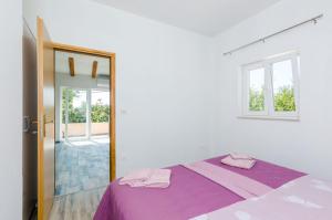 a bedroom with a purple bed and a mirror at Apartments Dubrovnik Airport in Čilipi