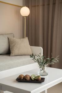 a white table with a plate of fruit on it at Artemis Apartments in Stalos