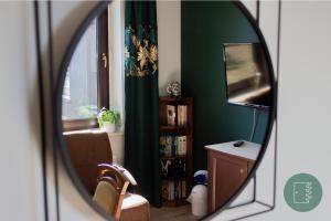een spiegelbeeld van een woonkamer met een groene muur bij Zielone Drzwi in Starachowice