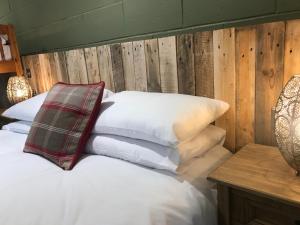 a bed with white pillows and a wooden wall at Rostrevor Mountain Lodge "Cosy & Friendly" in Rostrevor