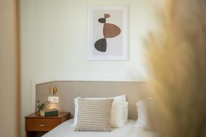sypialnia z łóżkiem i zdjęciem na ścianie w obiekcie Artemis Apartments w Stalós