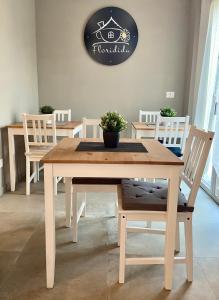 mesa de comedor con sillas y reloj en la pared en Floridida Rooms & Breakfast, en Andora