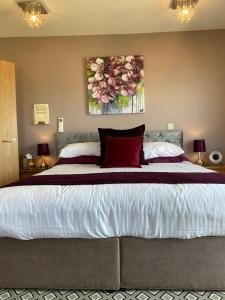 a bedroom with a large bed with red pillows at The Quies in Newquay
