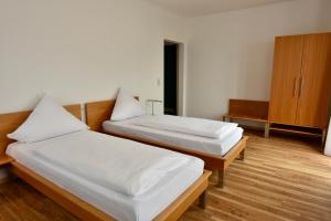 um quarto com 2 camas e um armário de madeira em Hotel Kranz em Gottmadingen