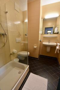 La salle de bains est pourvue d'une baignoire, de toilettes et d'un lavabo. dans l'établissement Hotel Kranz, à Gottmadingen