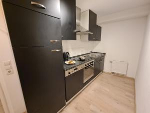 a kitchen with a black refrigerator and a stove at Theox Apartment No 6 Royal Blue für 4 Personen in Mannheim