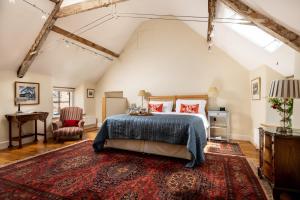 sypialnia z łóżkiem i czerwonym dywanem w obiekcie The Hayloft w mieście Kings Cliffe