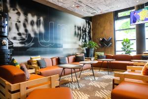 a waiting room with orange couches and tables at ibis Paris Porte de Clichy Centre in Clichy