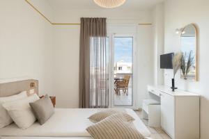 Biała sypialnia z łóżkiem i balkonem w obiekcie Artemis Apartments w Stalós