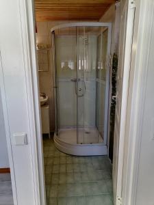 a shower with a glass door in a bathroom at Hostel Mansikka in Taipalsaari