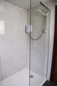 a shower stall with a glass shower door at Ardgarry Farm in Invergarry