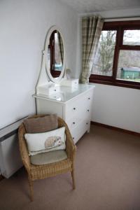 a bathroom with a chair and a mirror at Ardgarry Farm in Invergarry