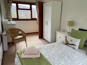 a bedroom with a bed, chair, and a dresser at Ardgarry Farm in Invergarry