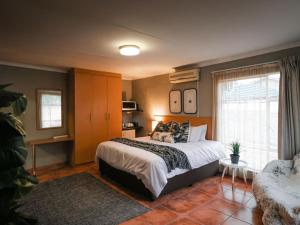 a bedroom with a bed and a couch at 16 Vaalrivier in Secunda