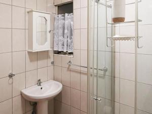 a white bathroom with a sink and a shower at 16 Vaalrivier in Secunda