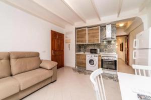 a living room with a couch and a kitchen at Mayor 7 by Seaward Suites in Villajoyosa