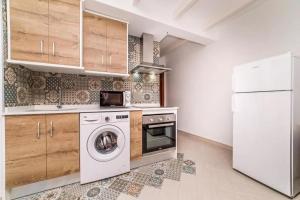 a kitchen with a washing machine and a refrigerator at Mayor 7 by Seaward Suites in Villajoyosa