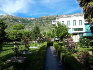 a garden in front of a building with mountains in the background at Beach Hiking Holiday Villa Luanit in Tragjas