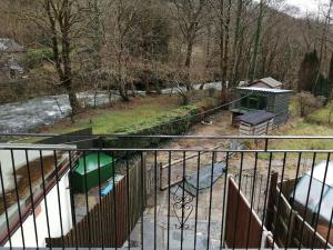 Blick auf einen Park mit einem Zaun und einem Spielplatz in der Unterkunft 1 Park Terrace in Corris