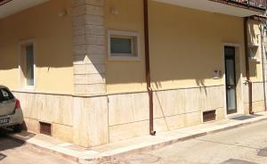 a building with a wooden wall on a street at Sweet Home Apartment in Grumo Appula +3 photos
