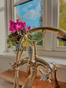 metalowe krzesło z wazą kwiatów na stole w obiekcie Tor Cottage, perfectly positioned! w mieście Glastonbury