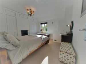 Schlafzimmer mit einem Bett, einem Kamin und einem Waschbecken in der Unterkunft Tor Cottage, perfectly positioned! in Glastonbury