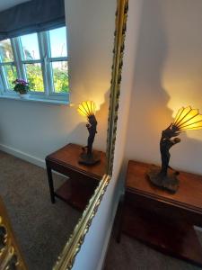 a mirror and a table with a lamp on it at Tor Cottage, perfectly positioned! in Glastonbury