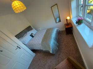 a bedroom with a bed and a mirror and a window at Tor Cottage, perfectly positioned! in Glastonbury +6 photos