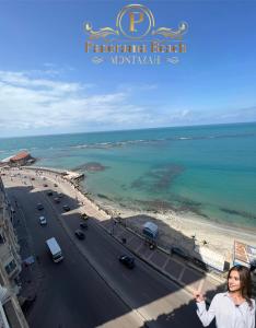 une femme debout au sommet d'un bâtiment près de l'océan dans l'établissement شقق بانوراما شاطئ الأسكندرية كود 10, à Alexandrie