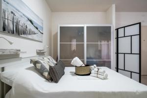 um quarto com uma grande cama branca e uma janela em Little house Bo, a pochi minuti dal Bellaria em San Lazzaro di Savena
