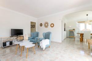 un soggiorno con tavolo e sedie blu di YourHouse Germanor, quiet beach house in Majorca North a Son Serra de Marina