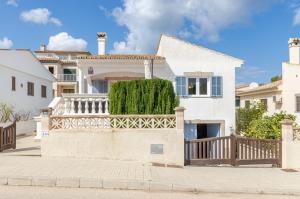 a white house with a wooden fence at YourHouse Germanor, quiet beach house in Majorca North in Son Serra de Marina