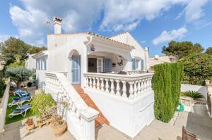 una grande casa bianca con scala e sedie di YourHouse Germanor, quiet beach house in Majorca North a Son Serra de Marina