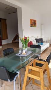ein Wohnzimmer mit einem Glastisch und Stühlen in der Unterkunft Residenzpark Willingen  Haus Langenberg in Willingen