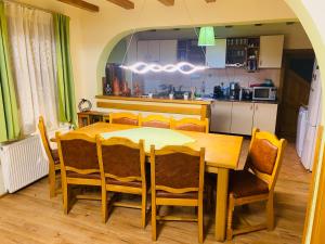 a kitchen with a wooden table and chairs in a kitchen at Casa din Vale in Moieciu de Sus +18 photos