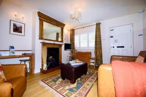 a living room with a couch and a fireplace at Victoria Cottage, Ironbridge in Ironbridge
