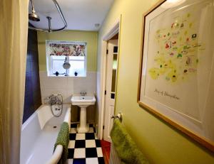 ein Badezimmer mit einem Waschbecken, einer Badewanne und einem Waschbecken in der Unterkunft Victoria Cottage, Ironbridge in Ironbridge