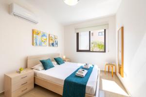 Un dormitorio con una cama con una manta azul. en Protaras Villa Angela Nefeli, en Paralimni