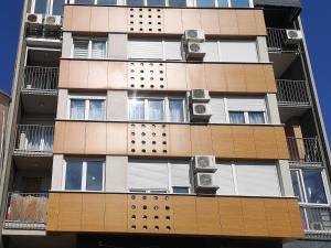 Edificio alto con ventanas y aire acondicionado en FilinHome Papa Suite 3, en Novi Sad