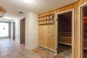 einen begehbaren Kleiderschrank mit Holzwänden und einer Glastür in der Unterkunft Dünenschloss Wohnung 4-03 in Kühlungsborn + 18 Fotos