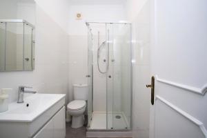 a white bathroom with a shower and a toilet at VistaoMar in São João do Estoril