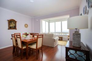 a living room with a dining room table and chairs at VistaoMar in São João do Estoril