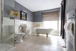 een badkamer met een bad, een toilet en een wastafel bij The Bull And Swan in Stamford