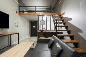 um apartamento loft com uma escada e um sofá em Malu Hotel Suwon em Suwon