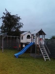 un parque infantil con tobogán y columpio en POKOJE GOŚCINNE AZALIOWA 34 Mielno, en Mielno