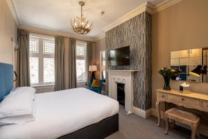 a bedroom with a bed and a fireplace and a television at The Fleece Hotel Richmond in Richmond